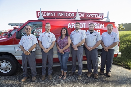 Six people stand in front of a company van